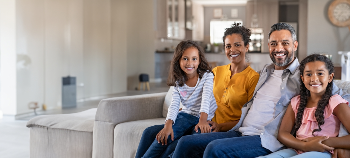 Family of four sitting on couch after visiting childrens dentist in Newark